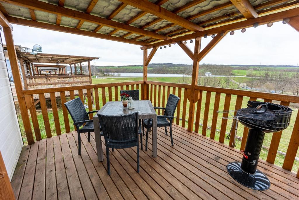 eine Terrasse mit einem Tisch und Stühlen auf einer Terrasse in der Unterkunft Mobilheim Chalet - Výrovická přehrada in Výrovice