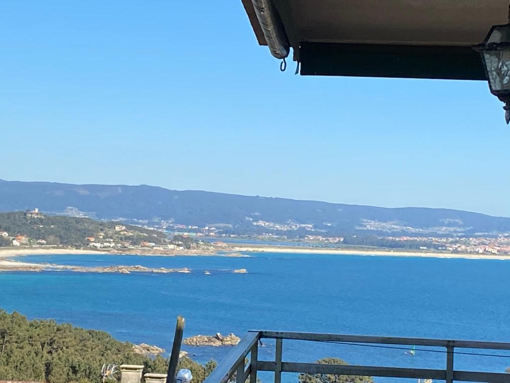 uma vista para o oceano a partir de uma varanda em SAN VICENTE DO MAR (URBANIZACIÓN PEDRAS NEGRAS) O GROVE- SANXENXO em O Grove