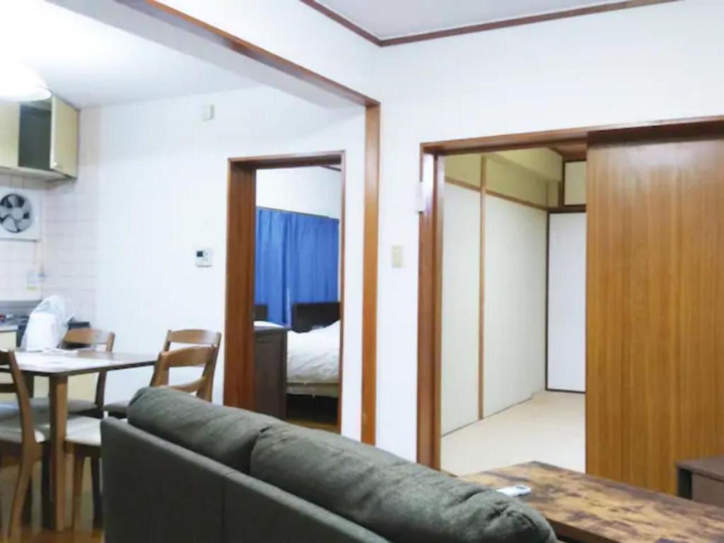 uma sala de estar com um sofá e uma sala de jantar em Maison Ota Building A Building B - Vacation STAY 11098 em Takamatsu