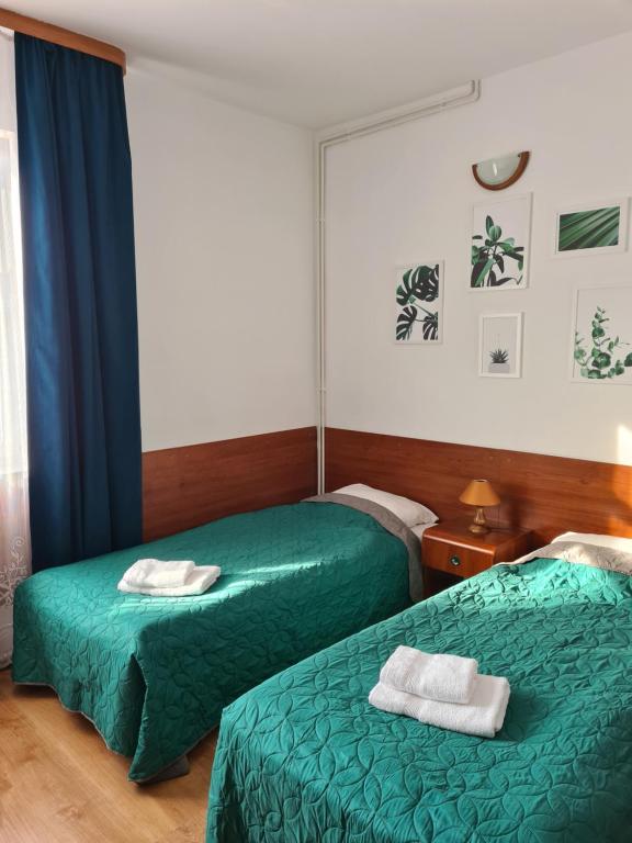 Dos camas en una habitación de hotel con toallas. en Pokoje gościnne Restauracji Don Roberto, en Frombork