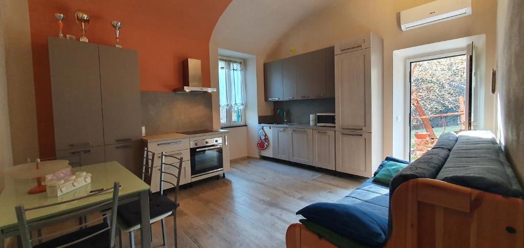 salon z kanapą i kuchnią w obiekcie La Casa degli Archi w mieście Tavarone