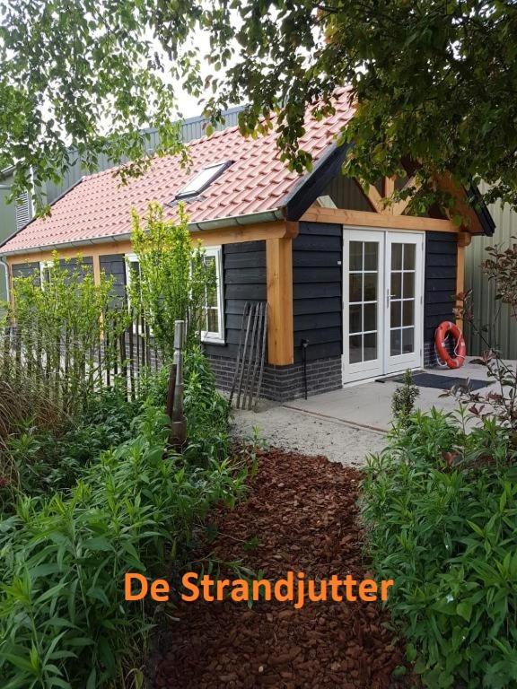 a small blue house with a porch and a door at Vakantie Ouddorp in Ouddorp