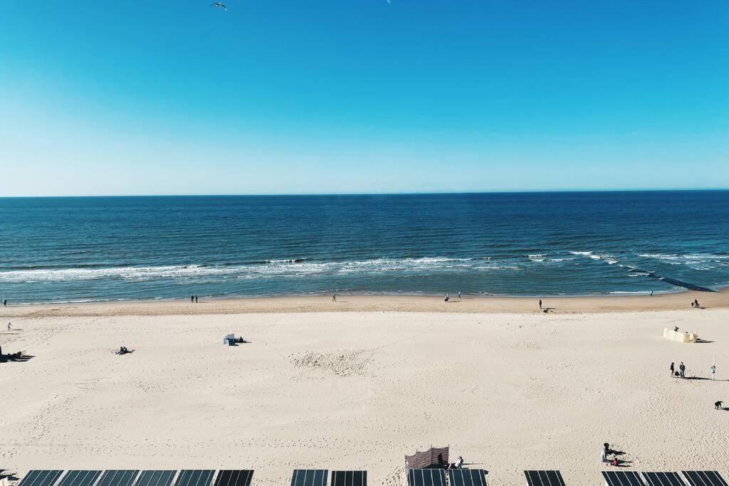 a beach with people on the sand and the ocean at Wonderful architect designed flat with sea view in Ostend