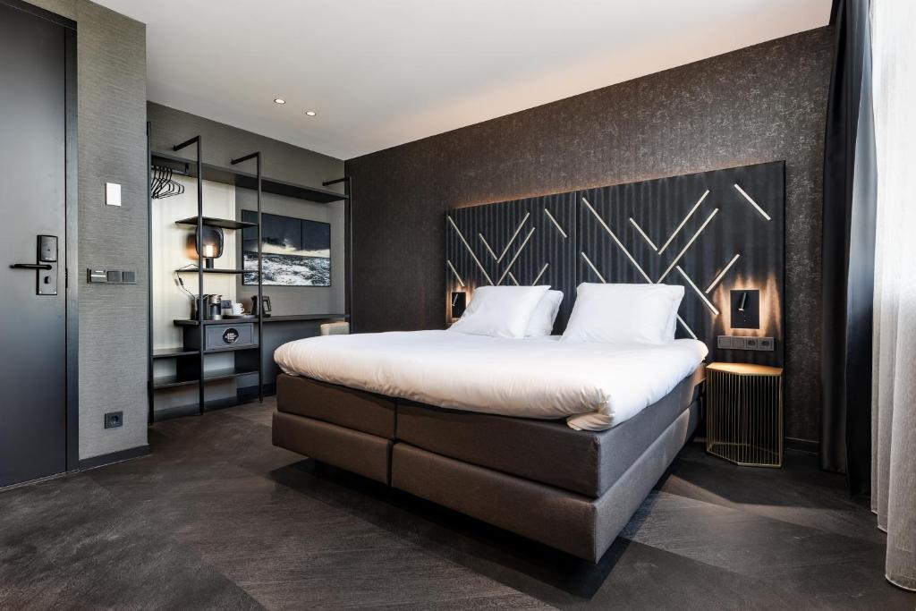 een slaapkamer met een groot bed met een zwarte muur bij Le Marin Hotel Rotterdam City - Handwritten Collection in Rotterdam