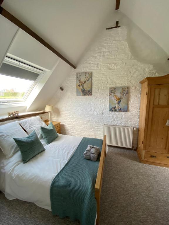 ein Schlafzimmer mit einem großen Bett im Dachgeschoss in der Unterkunft La Petite Maison - No 1 La Relierie in Gavray