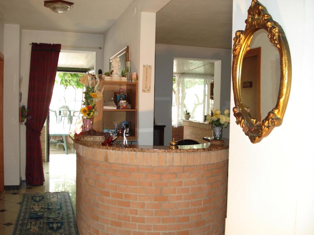 a room with a brick wall and a mirror at Albergo Edera in Salsomaggiore Terme