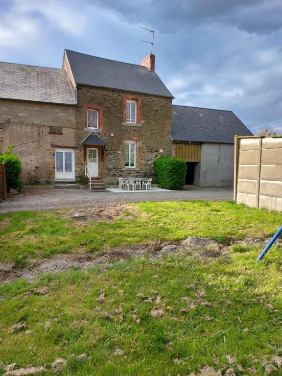 a large brick house with a yard in front of it at Ferme de la Ruette in Courtils