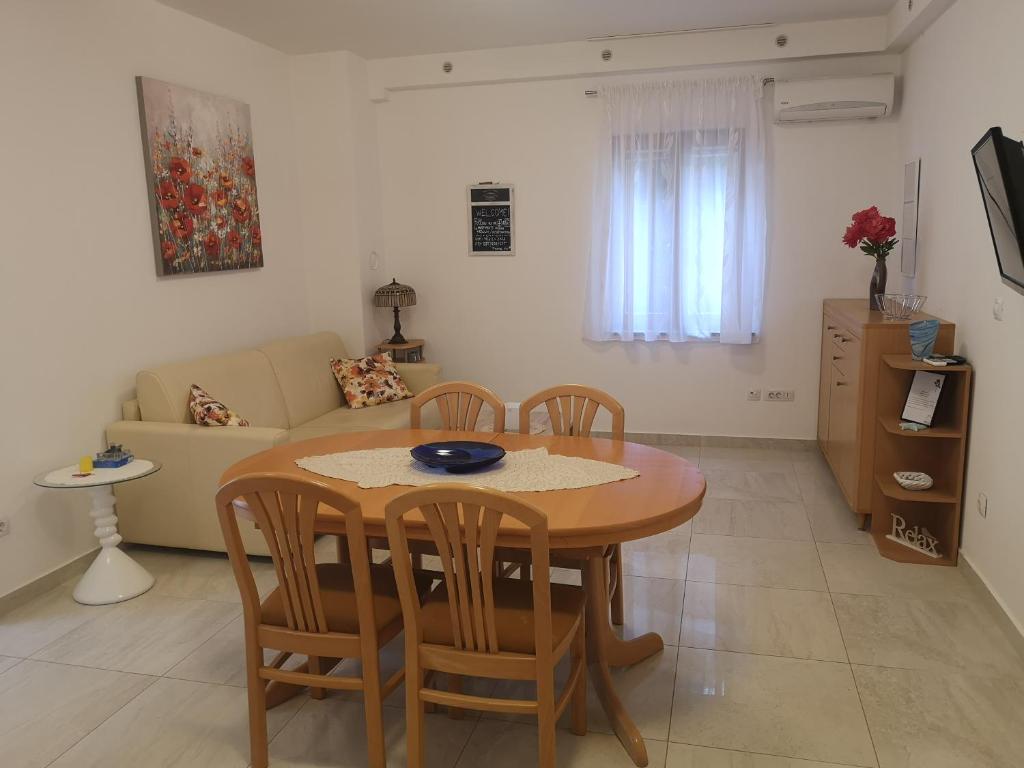 a dining room and living room with a table and chairs at Flowers apartments Medulin, Fucane 1A in Medulin