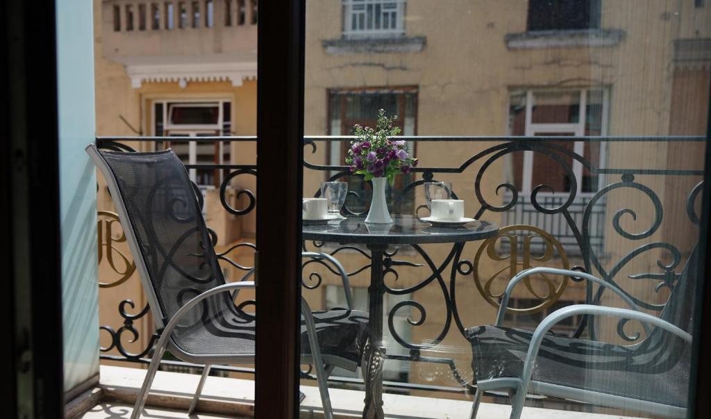 a table with a vase of flowers on a balcony at Hotel Gritti Pera & Spa in Istanbul