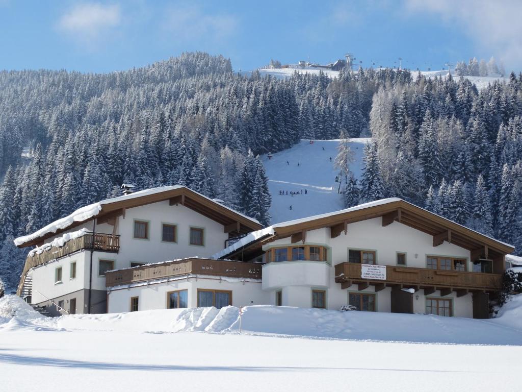 a building in the snow in front of a mountain at Apartments Fiechtl in Leogang