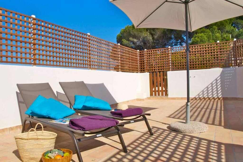 a patio with a table and an umbrella at Magallanes Apartment in Cala Ratjada