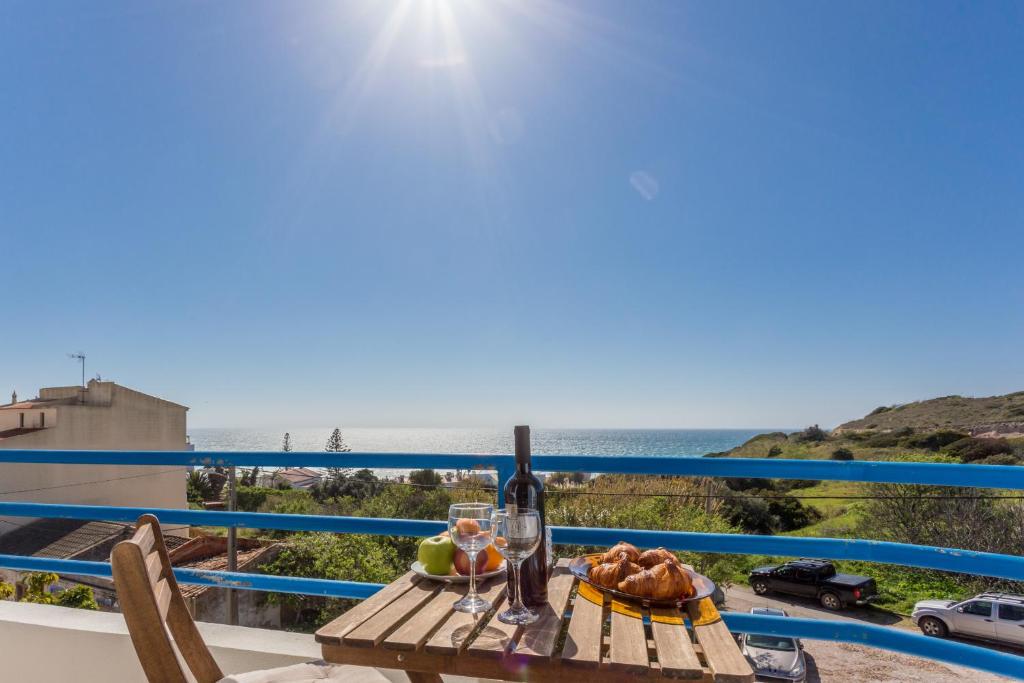 a table with a glass of wine and a view of the ocean at CoolHouses Algarve Luz, 2 Bed top floor flat, amazing sea view, central. Delicia do Sol in Luz