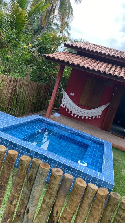 a swimming pool in a yard next to a house at Chalés Solar do Patacho in Pôrto de Pedras