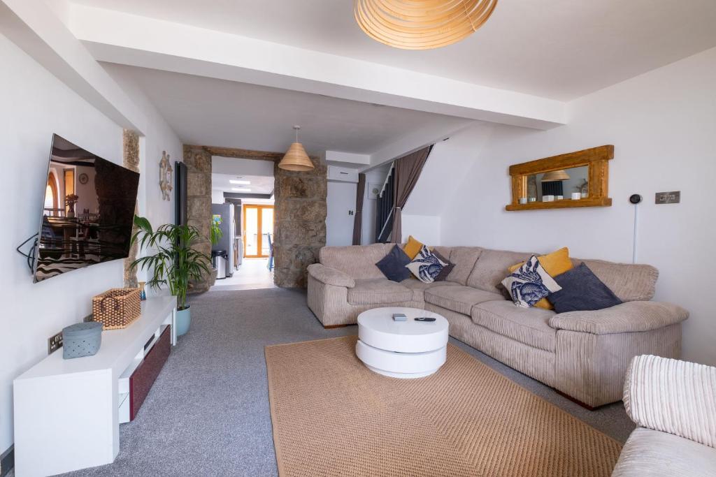 a living room with two couches and a table at Central Penzance, Modern stylish home, Near Seafront with Gated parking in Penzance