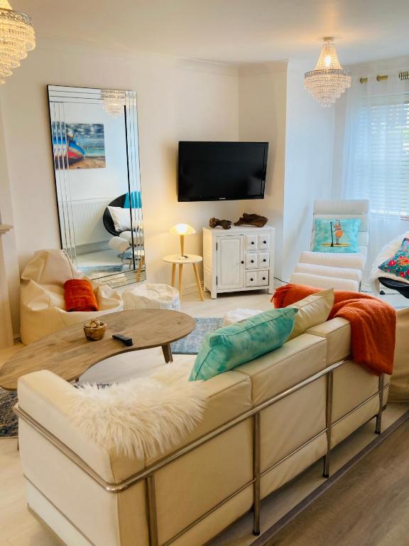 a living room with a couch and a tv at Stunning Seafront House with garden and private parking in Eastbourne