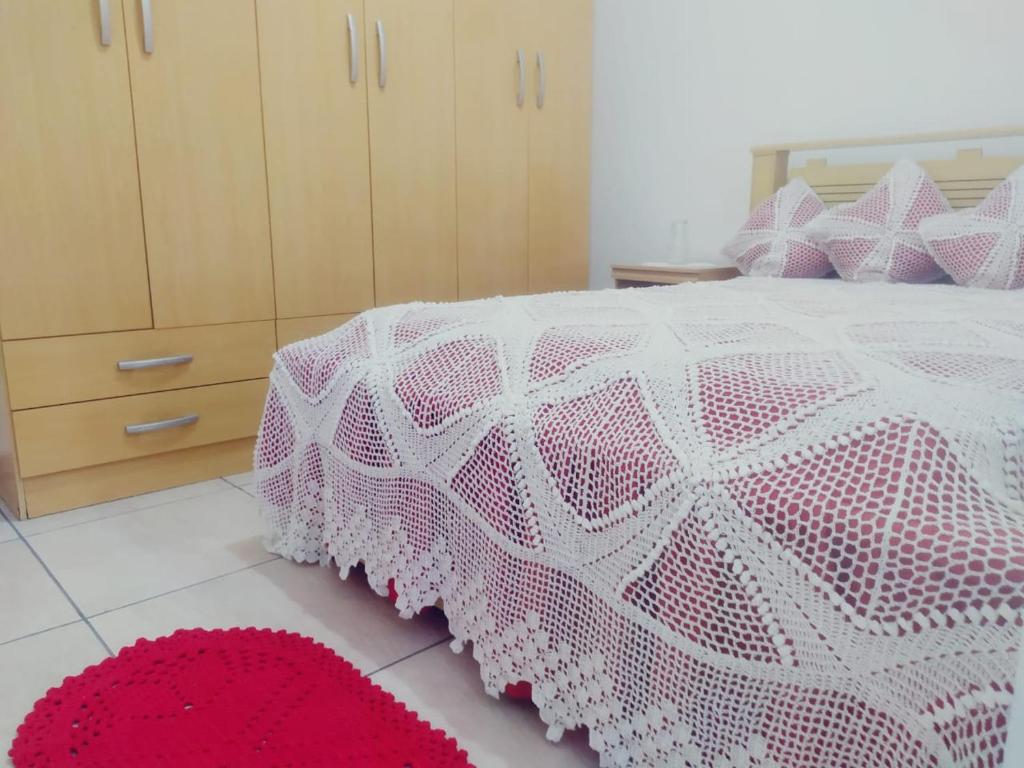 Un dormitorio con una cama rosa y blanca con una alfombra roja en Studio 137 ao Lado Metrô Internet 300MG en São Paulo