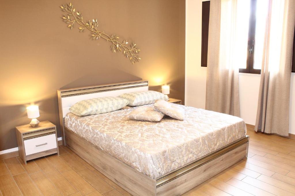 een slaapkamer met een bed met 2 kussens erop bij Villa Marchele in Carini