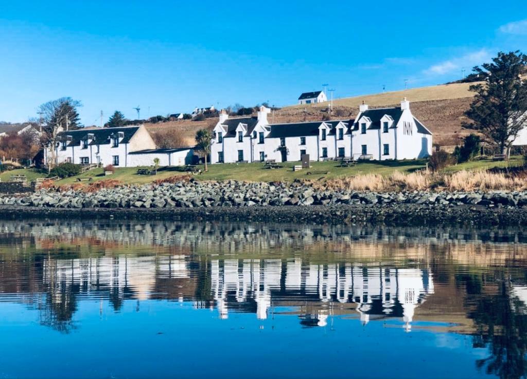 una grande casa bianca seduta accanto a un corpo d'acqua di Stein Inn a Stein