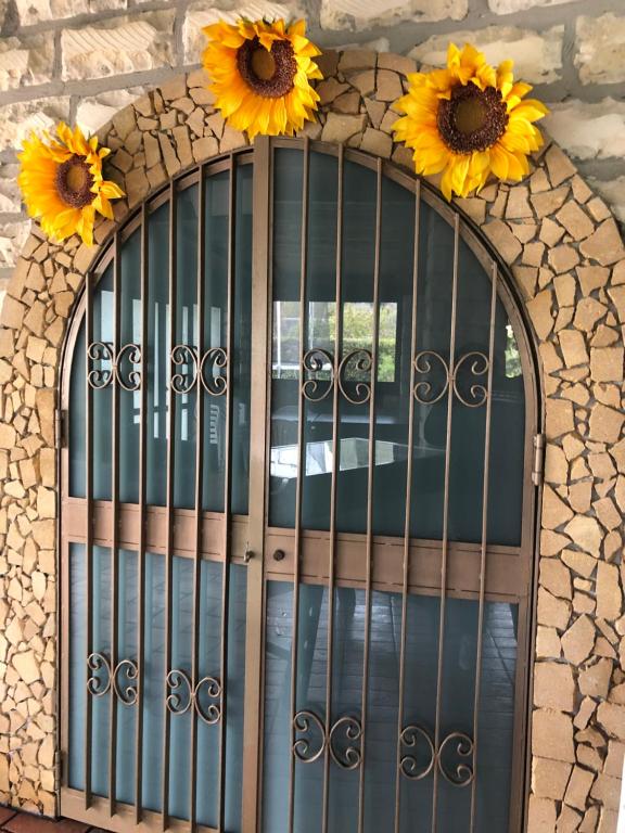 an iron gate with sunflowers on top of it at Oasi Bochini in Avola