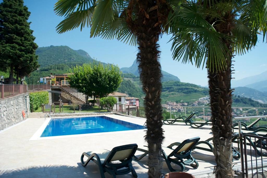 un complejo con una palmera y una piscina en Albergo Deva, en Riva del Garda