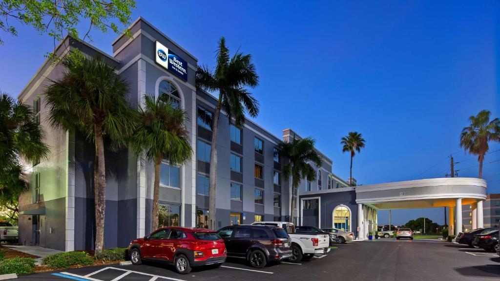 Best Western Fort Myers Inn and Suites في فورت مايرز: فندق فيه سيارات متوقفة في مواقف