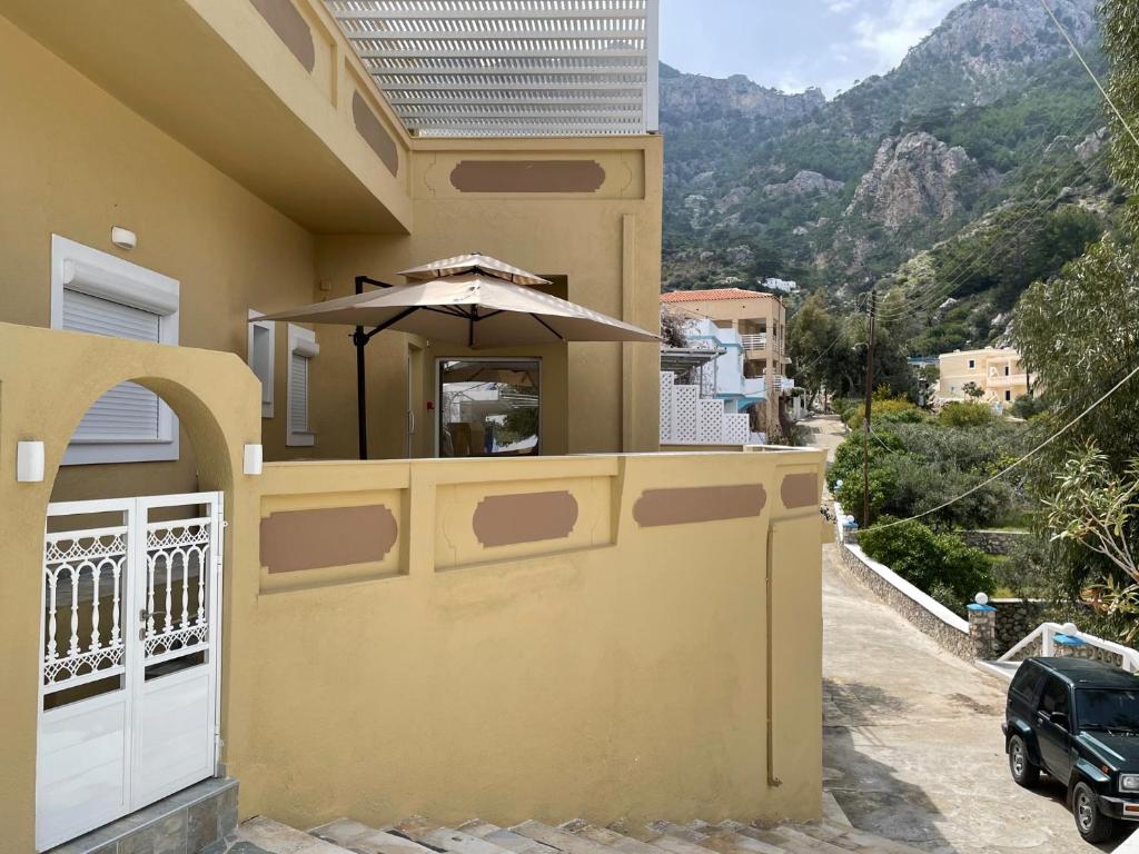 a house with an umbrella on the side of it at The View Condo No1 'The Michael' in Kyra Panagia