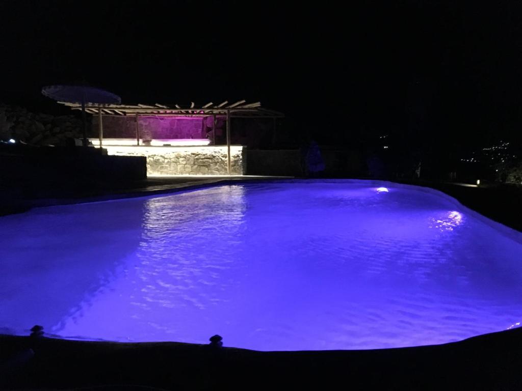 a large swimming pool lit up at night at My Oasis Studios Mykonos in Klouvas