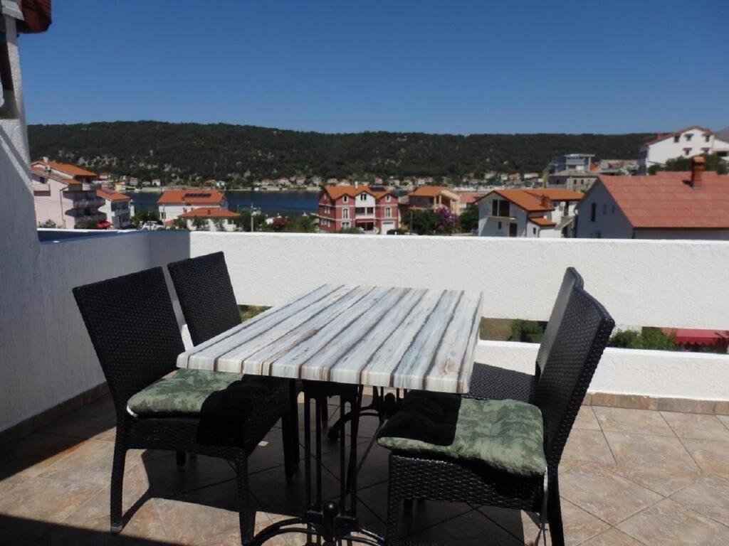 einen Holztisch und Stühle auf dem Balkon in der Unterkunft Apartments Suzy - 80m from the sea in Supetarska Draga