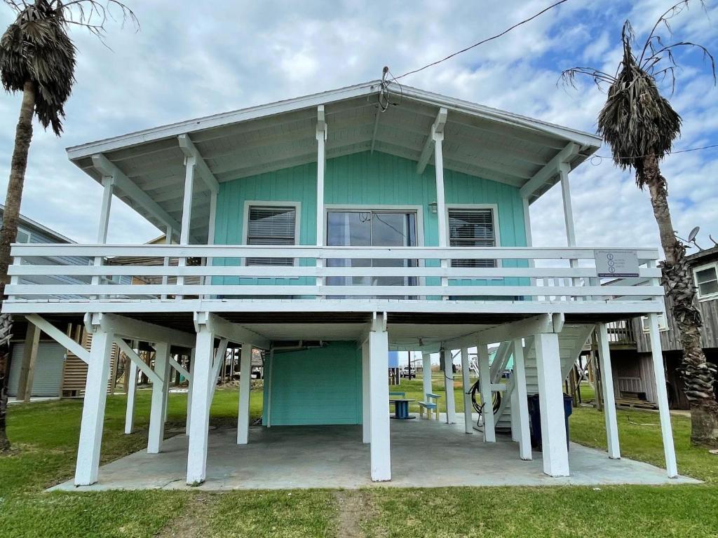 een groen huis met een groot terras erop bij Fun in the Sun! Cozy Beach Pad, Gulf Views and Easy Access to the Sand! in Surfside Beach