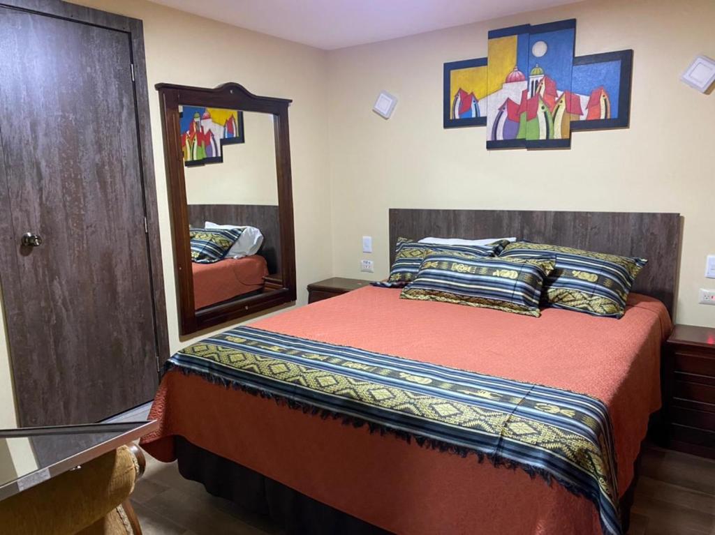 a bedroom with a bed and a large mirror at Samariwasi Hotel Boutique in Quito