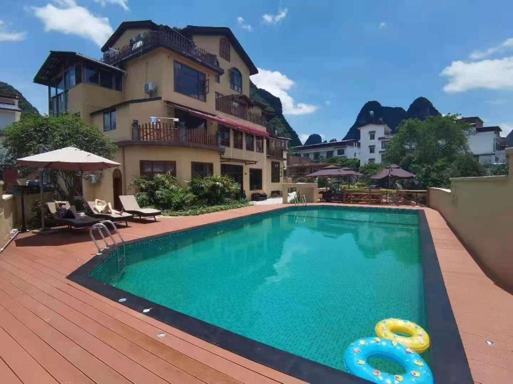 a large swimming pool in front of a house at Yangshuo Coco Garden Hotel in Yangshuo