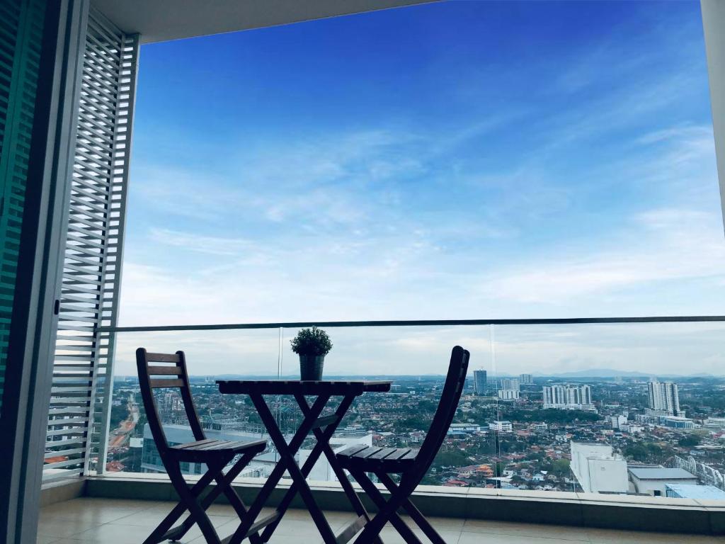 a table and two chairs in front of a large window at KSL Desplanade By Antlerzone in Johor Bahru