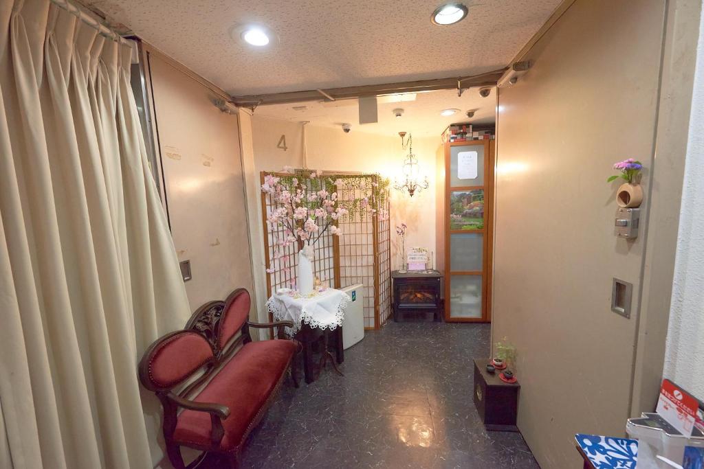 a living room with two chairs and a table at ホテル4Fマカロニ in Osaka