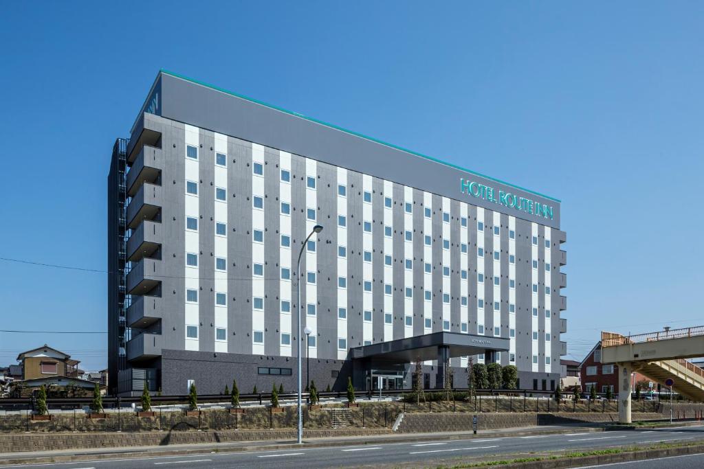 a large hotel building with a road in front of it at Hotel Route-Inn Kisarazu in Kisarazu
