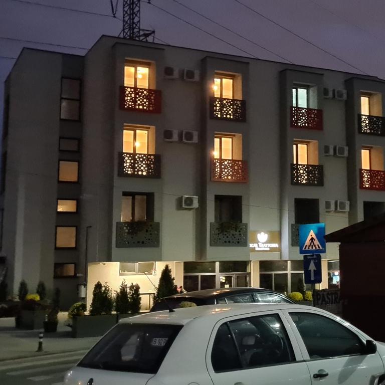 Ein weißes Auto parkte vor einem Gebäude in der Unterkunft Albert Hotel in Roşu