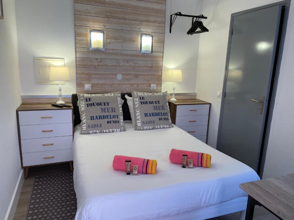 a bedroom with a bed with two pillows on it at Hotel et Résidence Chez Gino Le Touquet-Etaples in Étaples