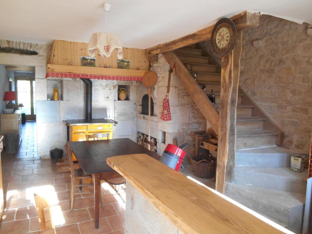uma cozinha com uma mesa de madeira num quarto em Sancier gîte au calme grand terrain circuit cascades du Hérisson em Saugeot