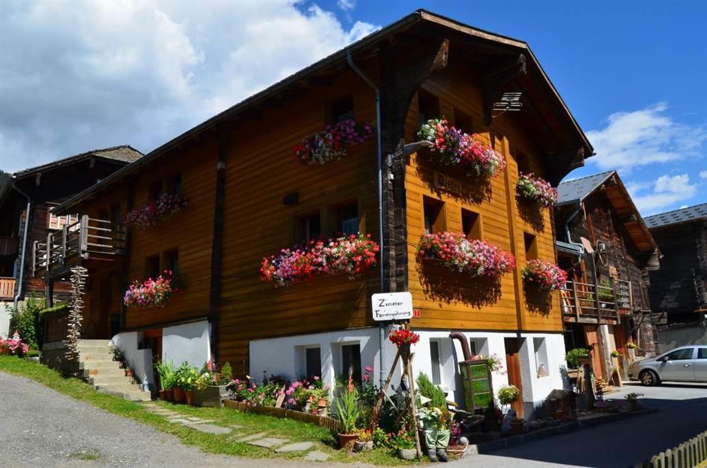 ein Holzgebäude mit Blumenkästen darauf in der Unterkunft Distel in Ritzingen