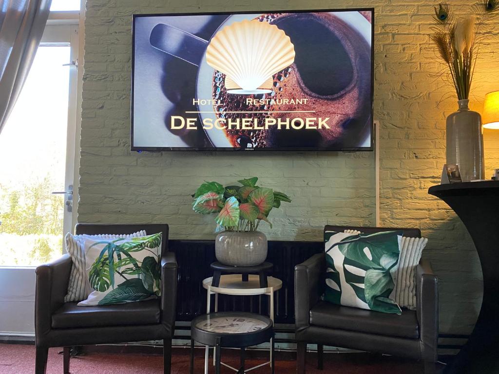 Pokój z dwoma krzesłami i zdjęciem na ścianie w obiekcie HCR de Schelphoek w mieście Serooskerke