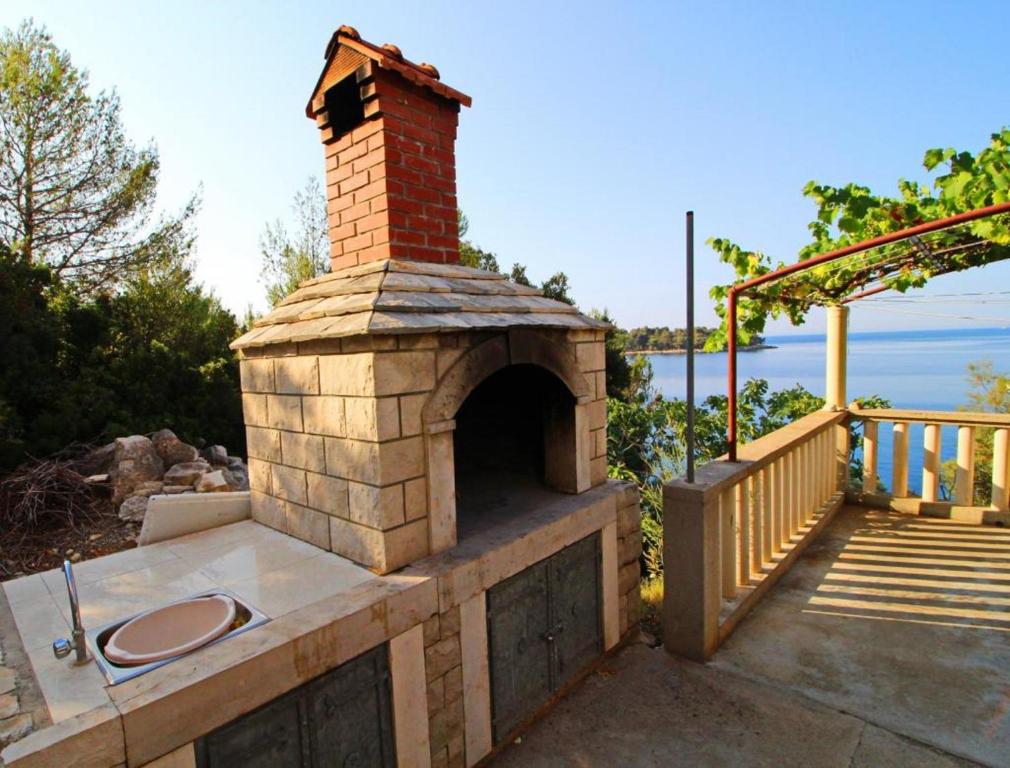a brick oven on a patio next to a deck at Apartments Bacic in Prizba