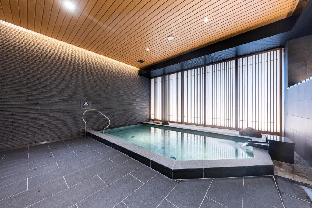 a swimming pool in a room with a brick wall at Hotel Kazusaya in Tokyo