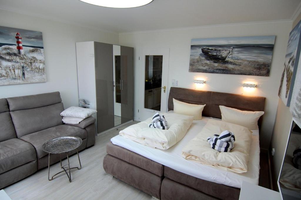 ein Wohnzimmer mit einem Bett und einer Couch in der Unterkunft Arielle in Westerland