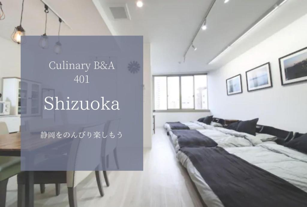 1 dormitorio con 1 cama grande y 1 mesa en Culinary Bed&Art 401 en Hamamatsu