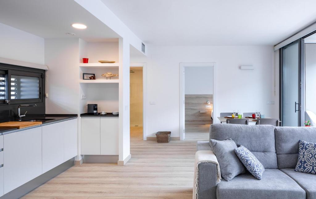 a living room with a couch and a kitchen at Apartaments La Rosella in Roses