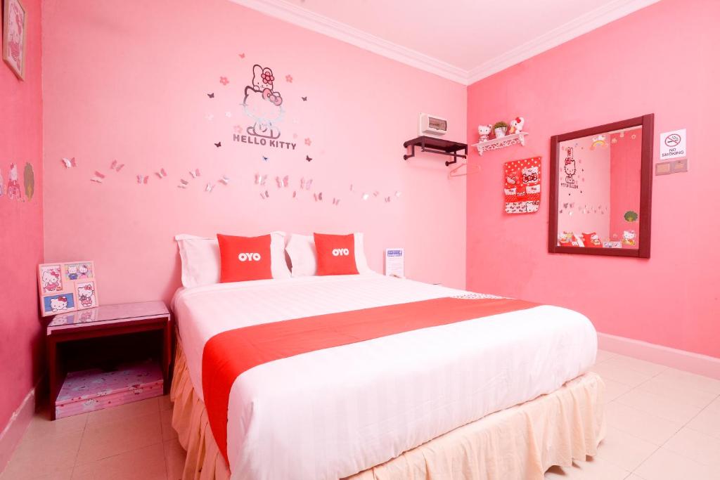 a pink bedroom with a large bed in it at OYO 89958 Hotel Umimas in Lahad Datu