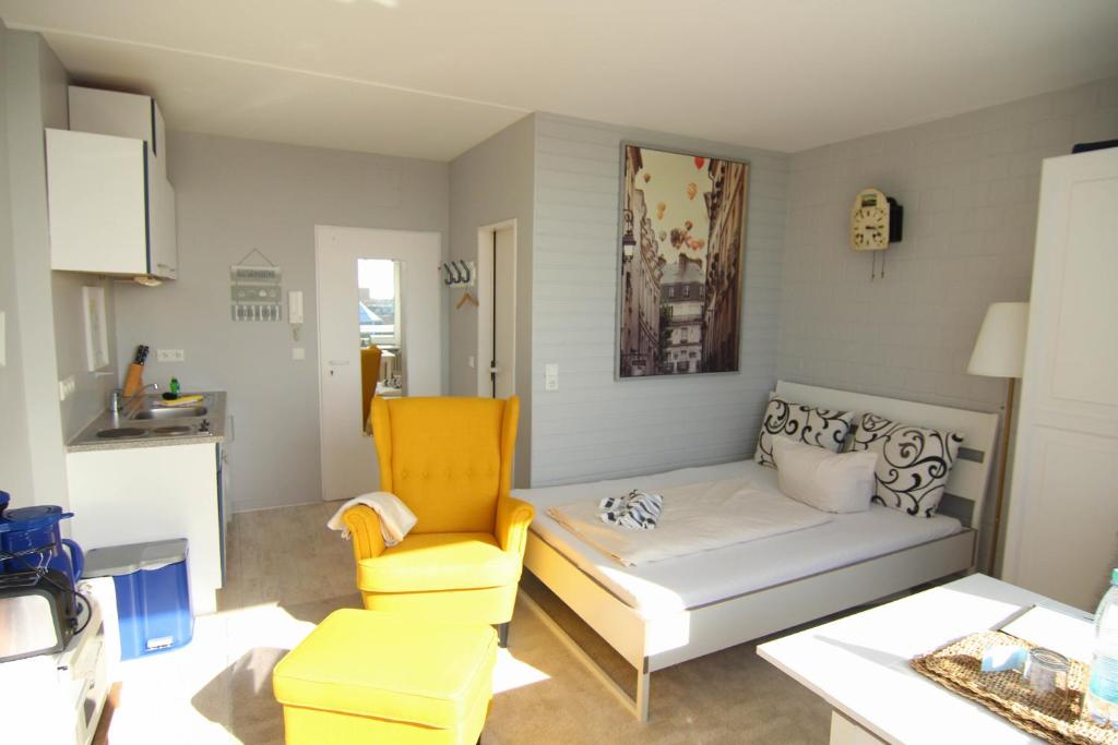 een woonkamer met een bank en een gele stoel bij Kiekerwai in Westerland