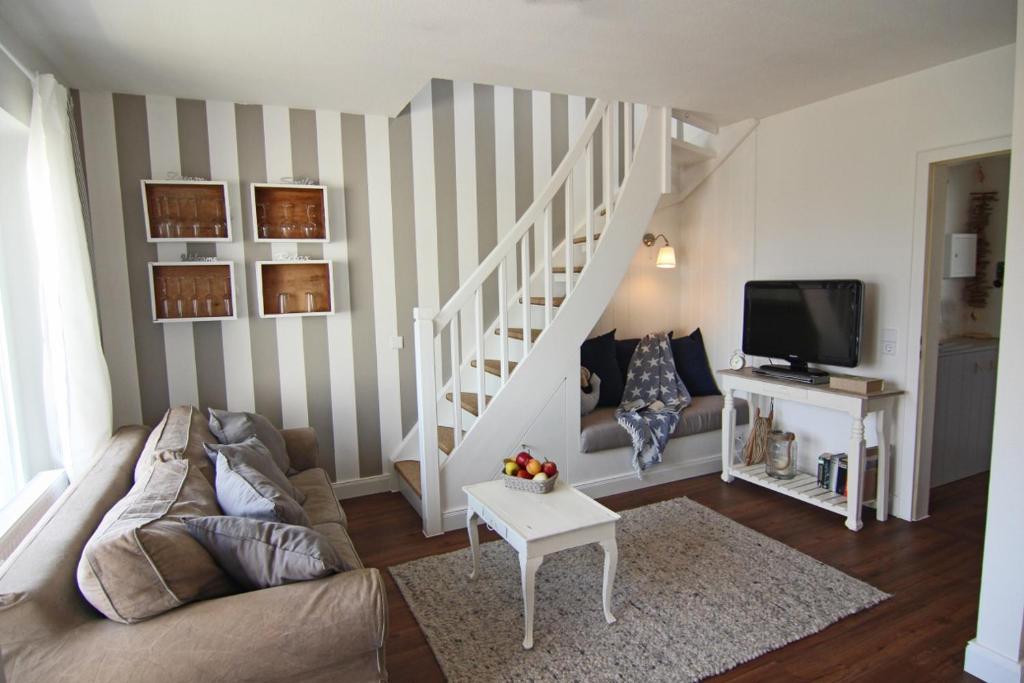 ein Wohnzimmer mit einem Sofa und einem TV in der Unterkunft Muck in Westerland