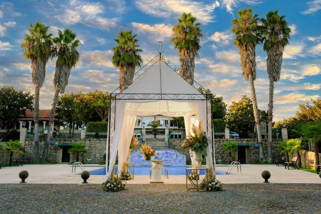 a wedding altar with palm trees in the background at Quinta de Resela in Vila Verde