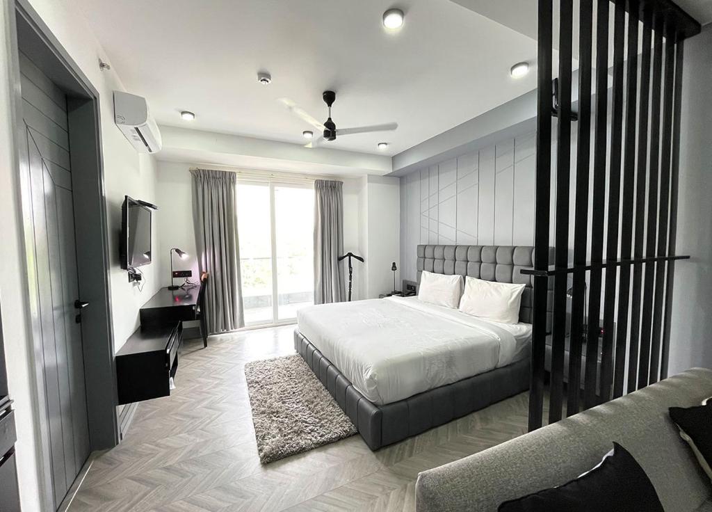 a bedroom with a bed and a television in it at BedChambers Serviced Apartments, MG ROAD in Gurgaon