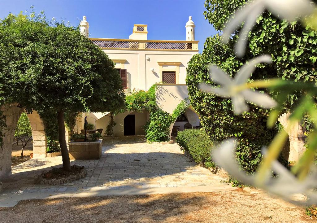 普爾薩諾的住宿－Antica Casina B&B di Charme，前面有树木的白色房子